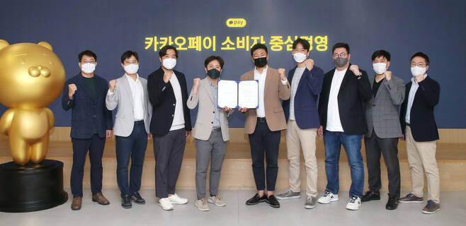Kakao Pay Chief Executive Officer Alex Ryu (fifth from left) and staff pose for a photo during a ceremony held at its headquarters Friday. (Kakao Pay)
