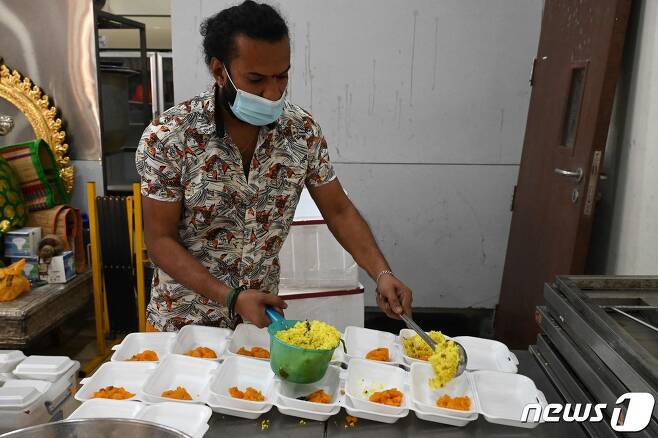 싱가포르의 한 식당에서 직원이 마스크를 쓴 채 업무를 보고 있다. © AFP=뉴스1