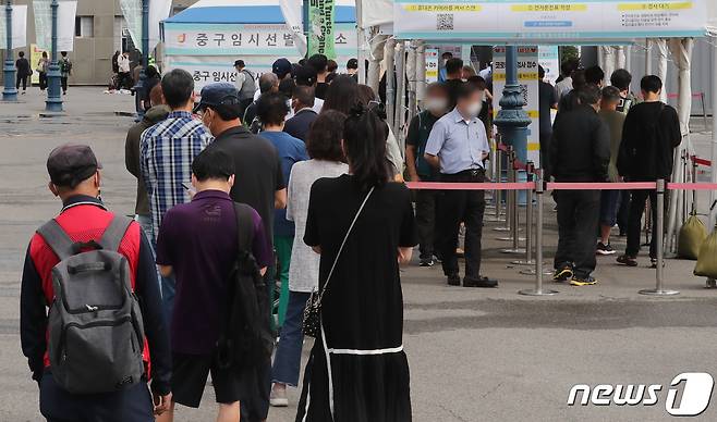 25일 오전 서울 서울역광장에 마련된 중구 선별검사소에서 시민들이 코로나19 검사를 받기위해 줄을 서서 기다리고 있다.  /뉴스1