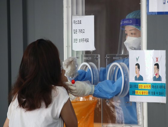 26일 오전 서울역 광장 앞에 마련된 임시선별검사소에서 의료진이 검체 채취를 하고 있다. 연합뉴스
