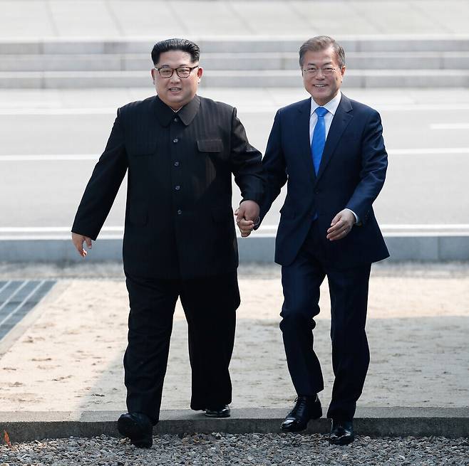 President Moon Jae-in and North Korean leader Kim Jong-un cross over the Military Demarcation Line at Panmunjom ahead of the 2018 inter-Korean summit held on April 27, 2018. (pool photo)
