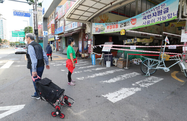 Shoppers walk past central Seoul’s Jungbu Market, which had been closed down until Sunday due to a cluster of COVID-19 infections. (Shin So-young/The Hankyoreh)