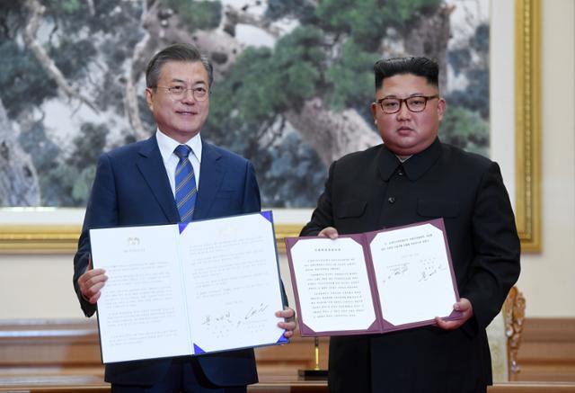 문재인(왼쪽) 대통령과 김정은 북한 국무위원장이 2018년 9월 19일 평양 백화원 영빈관에서 평양공동선언문에 서명한 후 합의서를 들어보이고 있다. 사진공동취재단