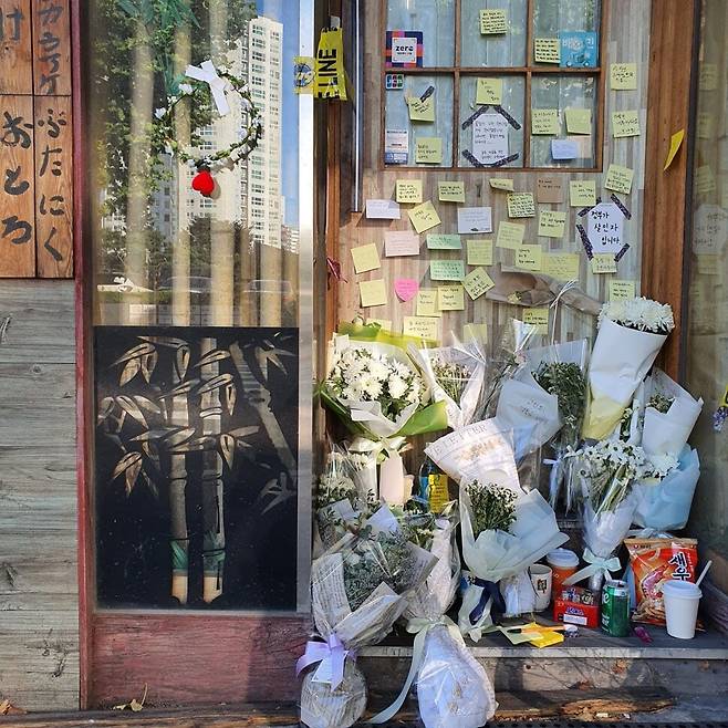 지난 9월7일 숨진 채 발견된 자영업자 ㄱ(57)씨가 운영하던 서울 마포구의 맥줏집 문 앞에 17일 오후 ㄱ씨를 추모하는 포스트잇과 조화가 놓여 있다. 정유경 기자
