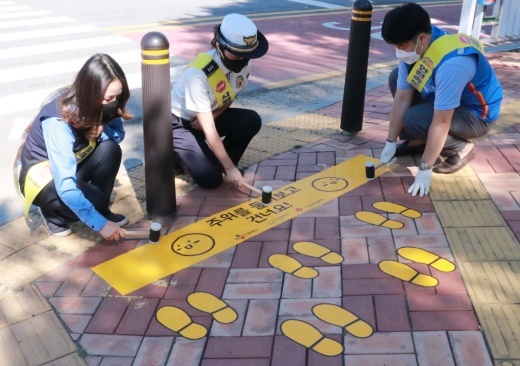 CJ대한통운이 경기도 군포시 어린이보호구역에 노란발자국을 설치하고 있다./사진제공=CJ대한통운