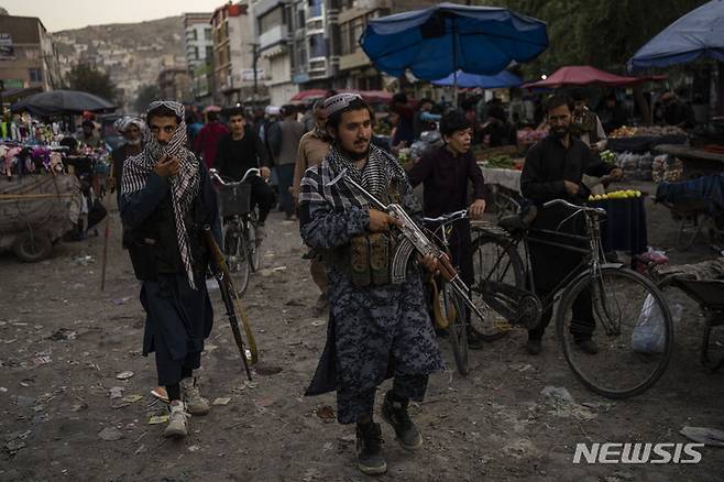 [카불=AP/뉴시스] 14일(현지시간) 탈레반 병사들이 아프가니스탄 카불의 한 시장을 순찰하고 있다. 미국과 나토가 아프간에서 철수하고 탈레반이 점령하면서 아프간은 경제 붕괴와 식량난으로 어려움이 더욱 늘어날 것으로 우려된다. 2021.09.15.