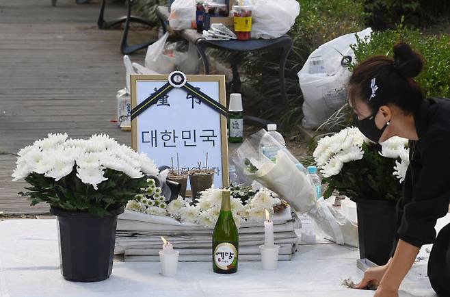 9월 17일 서울 여의도 국회의사당역 앞에 마련된 자영업자 합동분향소에서 관계자가 국화꽃 등 물품을 정돈하고 있다. (사진=연합뉴스)