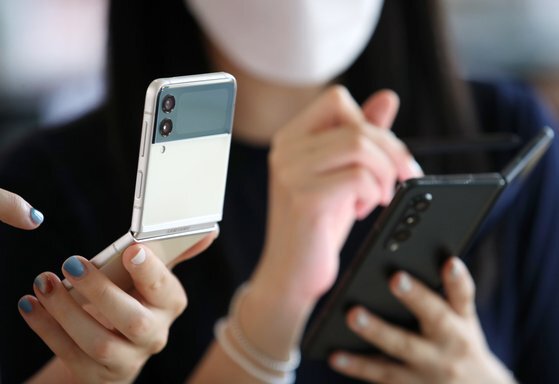 소비자들이 삼성전자의 폴더블폰 '갤럭시Z플립3'(왼쪽)과 '갤럭시Z 폴드3'를 사용해보고 있다. [뉴시스]