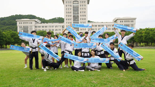 Students at Sun Moon University hold up signs to promote the Chungcheong area’s bid to host the 2027 Summer World University Games. (Chungcheong Megacity Bid Committee)