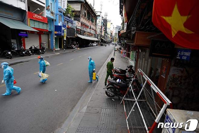 2주간 봉쇄 조치가 내려진 베트남 호치민 시내에 의료진들이 거주민 대상 신종 코로나바이러스 감염증 진단 검사 샘플을 모으고 있다. 2021.07.09 © AFP=뉴스1