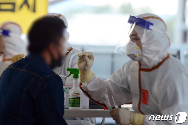 광주 광산구 하남주차타워에 설치된 이동식 선별진료소에서 시민들이 검체 채취를 받고 있다./뉴스1 DB © News1 정다움 기자