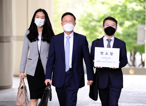 Lawyer Kang Sin-seob of Shin & Kim LLC, center, the attorney for SK Broadband heads to the Seoul High Court to file a counter-suit against Netflix on Thursday with his team. [SK BROADBAND]