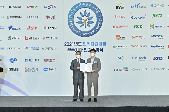 정명은 이지지오 과장(사진 오른쪽)과 김영중 고용노동부 고용정책실장이 '2021년도 인적자원개발 우수기관 인증수여식'에서 기념사진을 찍고 있다/사진제공=이지지오