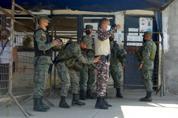 28일(현지시간) 에콰도르 콰야킬의 리토랄 교도소에서 갱단 소속 재소자 간에 서로 수류탄 등을 이용해 공격하는 등 폭동이 발생해 군이 출동해 이를 진압하고 있다. 콰야킬=AFP연합