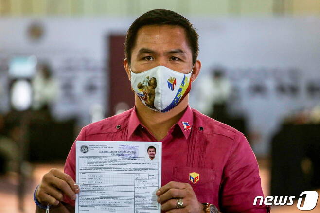내년 5월 필리핀 대선에 출마하는 '팩맨' 매니 파퀴아오가 자신의 후보 등록서를 들고 포즈를 취하고 있다. © 로이터=뉴스1