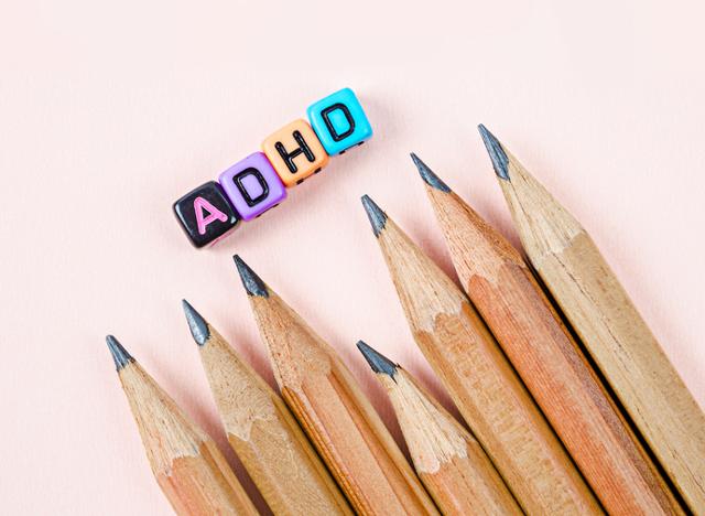 Attention Deficit Hyperactivity Disorder or ADHD concept with wooden pencil on paper background.