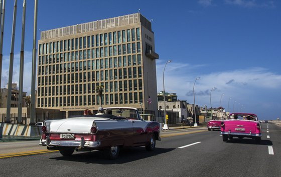 쿠바 아바나에 있는 미국 대사관 옆을 클래식 컨버터블 자동차를 탄 관광객들이 지나고 있다. 미국 외교관, 정보 장교, 군인들 사이에는 에너지 파동을 방출하는 장치로 인해 발생한 것으로 의심되는 '하바나 증후군'을 호소하는 경우가 늘고 있다. [AP=연합뉴스]