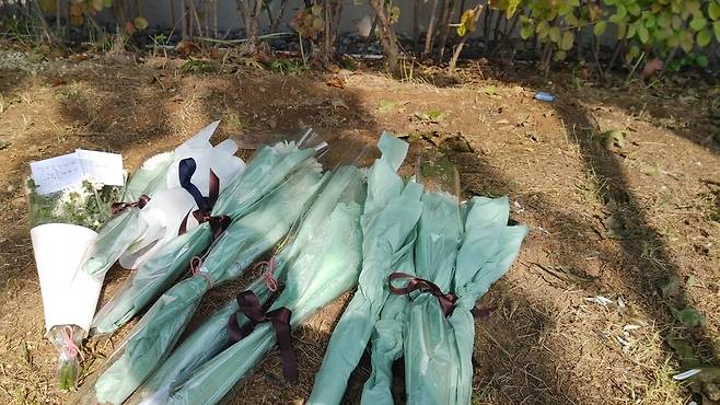 지난 1일 차아무개씨의 추락 사고 현장에 주민들이 애도의 뜻을 담은 꽃다발을 놓아둔 모습. 왼쪽 꽃다발에는 어린아이가 쓴 것으로 보이는 포스트잇이 붙어 있다. 포스트잇에는 삐뚤빼뚤한 글씨체로 “형아 좋은데가서 행복하게 지내야되(돼)”, “우리를 위해 외벽청소를 하시다가 돌아가셔서 슬퍼요. 그곳에서 잘 살아가세요”라고 적혀 있었다. 이승욱 기자