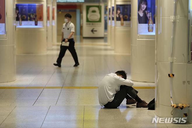 [도쿄=AP/뉴시스] 지난 7일 일본 도쿄 인근 지바현에서 규모 5.9의 지진이 발생해 모든 열차 운행이 일시 중단되면서 한 남성이 도쿄역 바닥에 주저앉아 있다. 2021.10.08.
