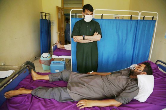 지난 7월 아프간 잘랄라바드의 코로나19 병동에 한 남성이 산소 마스크를 쓰고 누워있다. 최근 아프간 내 코로나 감염 사례가 급증하고 있지만 정확한 테스트와 수치가 없어 팬데믹 상황 파악이 어렵다. 연합뉴스