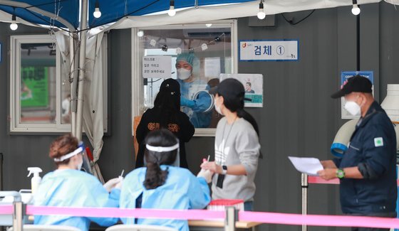14일 오전 서울 중구 서울역 광장에 마련된 신종 코로나바이러스 감염증(코로나19) 선별진료소를 찾은 시민들이 검사를 받고 있다. 뉴스1