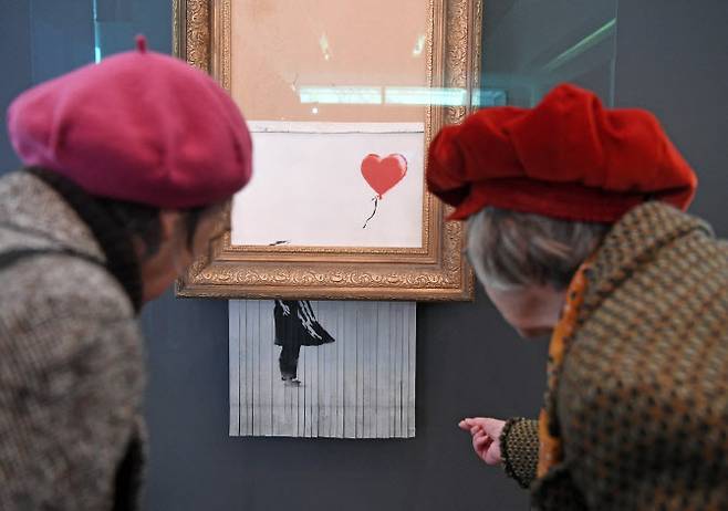 독일의 한 미술관에 전시돼 있는 ‘사랑은 쓰레기통에’를 관람객이 감상하고 있다. (사진= AFP)