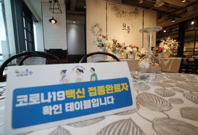 지난 4일 서울 시내 한 돌잔치 전문업체 매장 내 테이블에 백신 접종 완료 사실을 확인하는 안내문이 놓여 있다. 연합뉴스