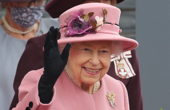 14일(현지시간) 엘리자베스 2세 여왕이 웨일스 의회 개회식에 참석하며 취재진을 향해 손을 들어 인사하고 있다.[AFP=연합뉴스]