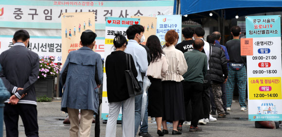 15일 서울 중구 서울역광장에 마련된 신종 코로나바이러스 감염증(코로나19) 선별진료소를 찾은 시민들이 검사를 위해 대기하고 있다. 뉴스1
