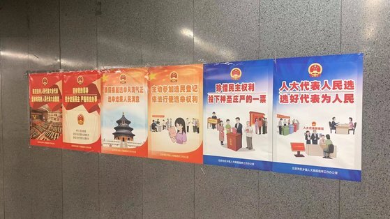 지난 13일 베이징 지하철 자오잉 역사에 붙어 있는 지방 인민대표 선거를 알리는 선전 포스터. 공산당의 영도를 견지해 민주를 충분히 발양하고, 엄격하게 법에 따라 일을 처리한다는 등의 표어가 보일 뿐 출마 후보자나, 투표 일시나 장소 등을 알리는 정보는 전혀 보이지 않는다. 신경진 기자
