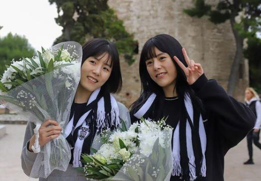 이재영(왼쪽)과 이다영이 17일 그리스 테살로니키에 도착해 꽃다발을 안고 기념사진을 찍고 있다.    PAOK 구단 SNS 캡처