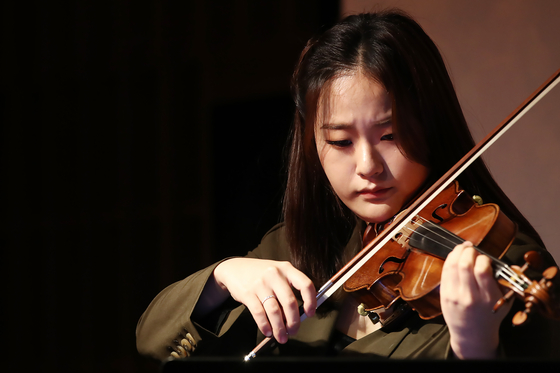Violinist Lim Ji-young, who is taking part in the global "The [Uncertain] Four Seasons" project, showcases the recomposed version of Vivaldi’s ‘The Four Seasons’ by an artificial intelligence based on climate prediction data of Seoul in 2050" during a press conference held last week in Seoul. [YONHAP]