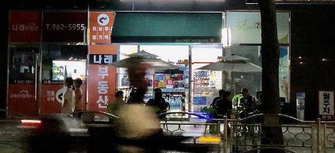 서울 동대문구에 위치한 한 편의점 앞 파라솔에서 이용객들이 맥주를 마시고 있다. [사진 = 신미진 기자]