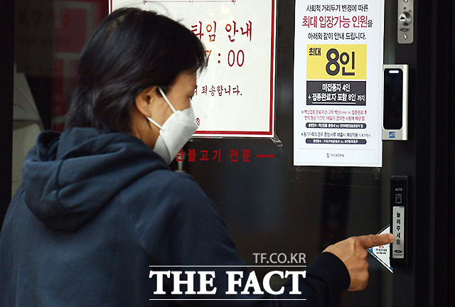 새로운 거리두기 조정안이 시행되는 18일 서울 종로구 한 식당에 수정된 안내문이 붙어 있다.
