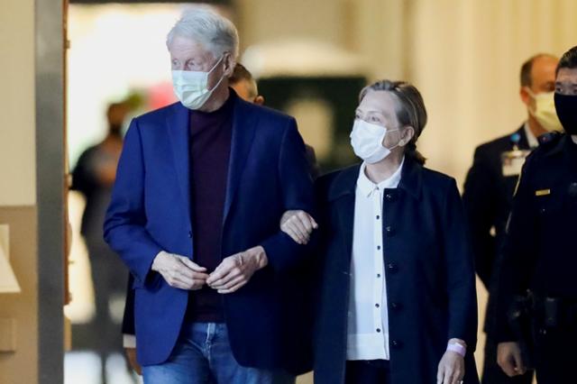 요로감염 증상으로 캘리포니아대 어바인병원에 입원했던 빌 클린턴(왼쪽) 전 미국 대통령이 17일 오전 부인 힐러리 클린턴 전 국무장관과 함께 걸어서 퇴원하고 있다. 오렌지=로이터 연합뉴스