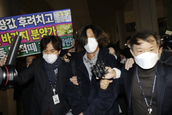 귀국 직후 체포된 남 변호사가 검찰 수사관들과 공항을 나서고 있다. 장진영 기자