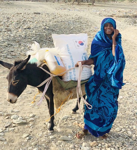 WFP를 통해 한국 쌀 원조를 받고 환하게 웃는 에리트리아 난민 케디아 (2021). [세계식량계획(WFP)]