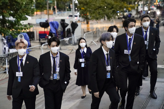 Members of the Korean band BTS arrive to security check-in at United Nations headquarters last month, during the 76th Session of the U.N. General Assembly in New York. They are wearing upcycled suits by Re;code. [AP.YONHAP]