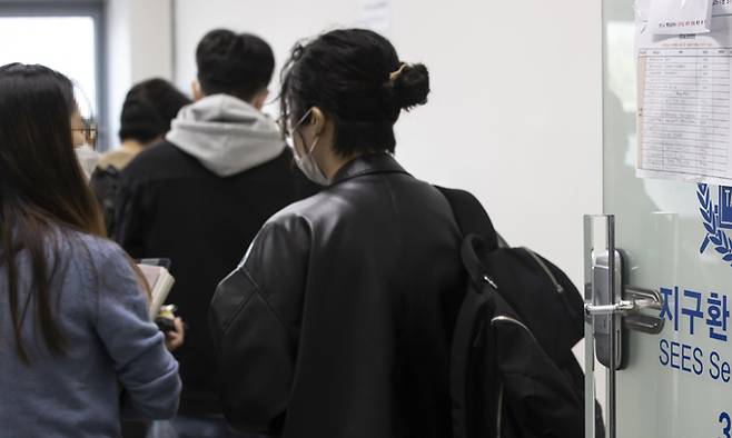 서울대가 대면 수업 기조로 전환한 첫날인 18일 학생들이 수업에 앞서 문진표 작성을 위해 줄을 서 있다. 연합뉴스