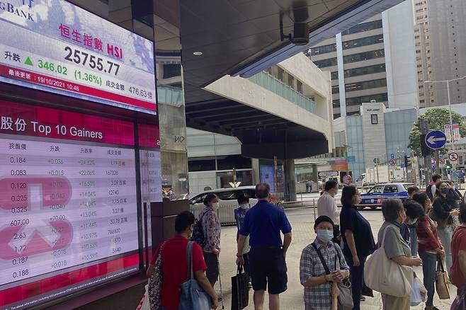19일 홍콩 항셍 주가 지수를 보여주는 은행의 전광판 앞을 사람들이 지나가고 있다./AP 연합뉴스