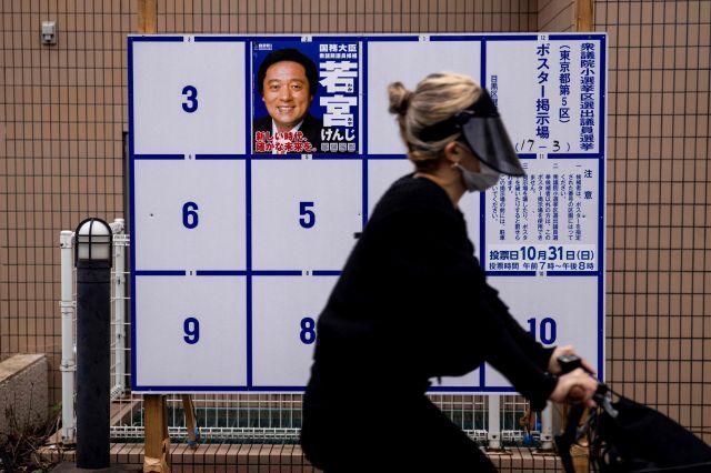 기시다 후미오 총리 내각의 신임을 묻는 일본 중의원 선거(총선)가 19일 후보 등록과 함께 막이 오른 가운데 도쿄 시내에 나붙은 집권 자민당 지역구 후보의 선거 벽보 앞으로 자전거를 탄 행인이 지나가고 있다. AFP연합뉴스