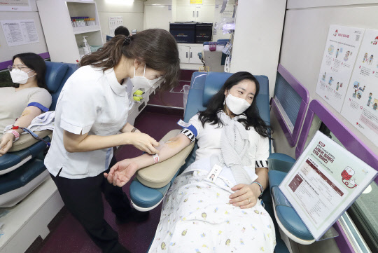 광화문원팀 소속 임직원이 대한적십자사 헌혈버스에서 헌혈을 하고 있다. KT 제공