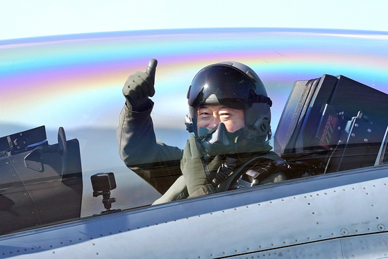 President Moon Jae-in gives a thumbs up from inside a FA-50 light fighter aircraft as he flies on Wednesday to Seoul Air Base in Seongnam, Gyeonggi, to deliver his congratulatory remarks to defense industry officials at the 2021 Seoul International Aerospace and Defense Exhibition. [JOINT PRESS CORPS]