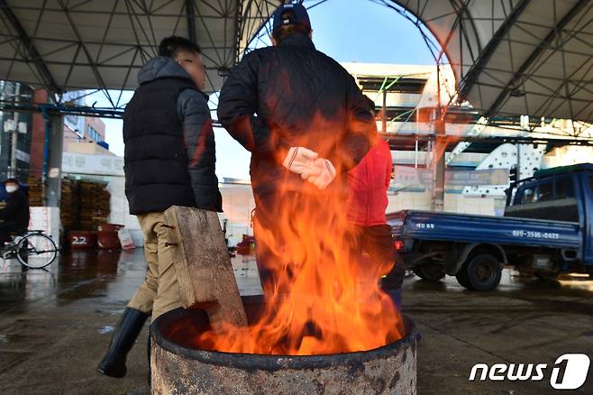 20일 경북 포항시 북구 죽도어시장에서 상인들이 모닥불에 몸을 녹이고 있다. 2021.10.20/뉴스1 © News1 최창호 기자