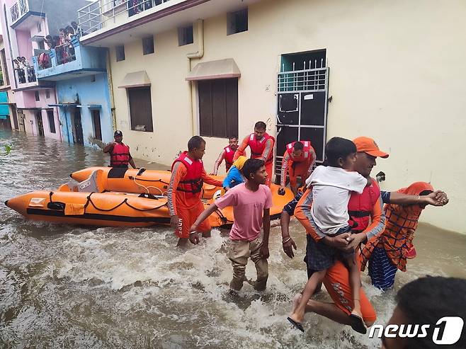 국가재난대응군(NDRP) 대원들이 19일(현지시간) 인도 북부 우타라칸드주의 우담 싱 나가르 지역에서 홍수 피해를 입은 주민들을 대피시키고 있다. © 로이터=뉴스1 © News1 노선웅 기자