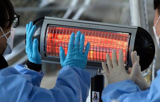 때이른 추위가 계속된 20일 대전 한밭운동장에 마련된 신종 코로나바이러스 감염증(코로나19) 선별진료소에서 의료진이 방문한 시민들을 검사한 뒤 잠시 전기난로에 손을 녹이고 있다.김성태/2021.10.20.