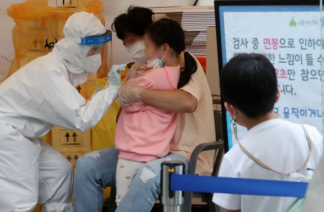 10월 12일 오후 서울 송파구 문정도시개발구역 광장 임시선별검사소에서 한 어린이가 다른 어린이의 검사를 지켜보고 있다. 뉴시스