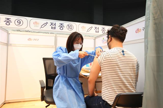 서울 구로구가 이달 말 코로나19 예방접종센터 운영을 종료한다. 사진은 예방접종센터에서 의료진(왼쪽)이 주민에게 백신 접종을 하는 모습.구로구 제공