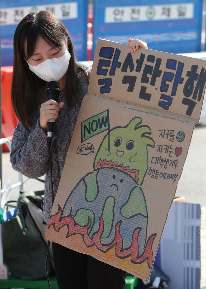22일 오전 서울 광화문 정부서울청사 앞에서 열린 ‘1022 글로벌 기후파업행동’에서 한 참석자가 자신이 가져온 손팻말을 소개하고 있다. 김태형 기자