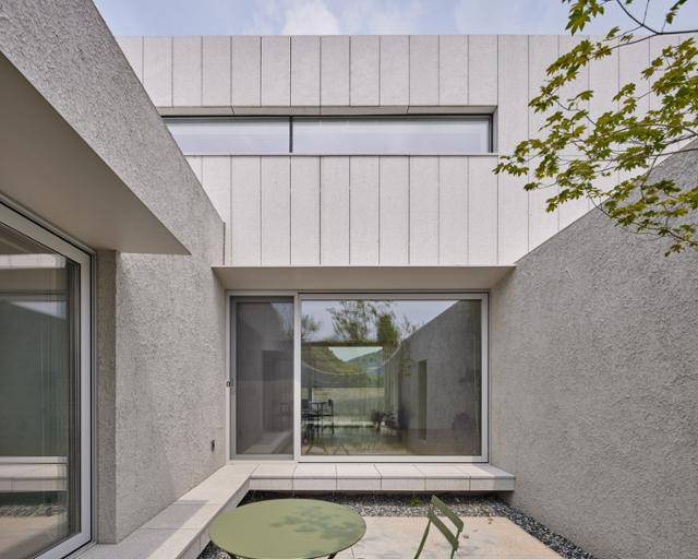 1층은 흙과 같이 거친 질감의 '스토', 2층은 매끈한 화강석으로 마감했다. 육중한 돌을 흙(땅)이 안정적으로 받치고 있다는 인상을 준다. 재료를 달리하는 대신 비슷한 색을 써서 외관의 통일감을 잃지 않았다. 노경 건축사진작가 제공